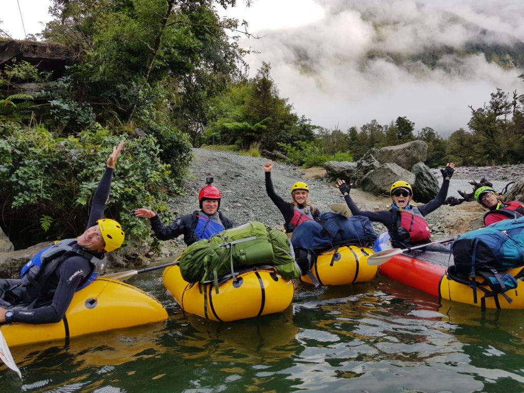 Packrafting team on the water celebrating